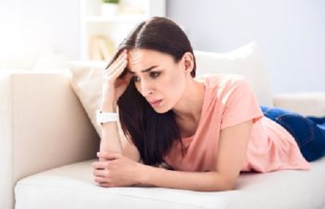 worried woman lying on the couch