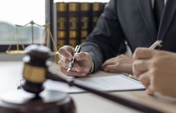 A lawyer with a client revising a claim at his legal office.