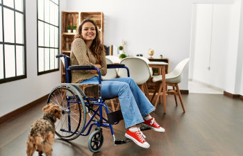 young beautiful woman in a wheelchair with dog smiles heartily