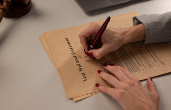 woman signing papers last wills at the office